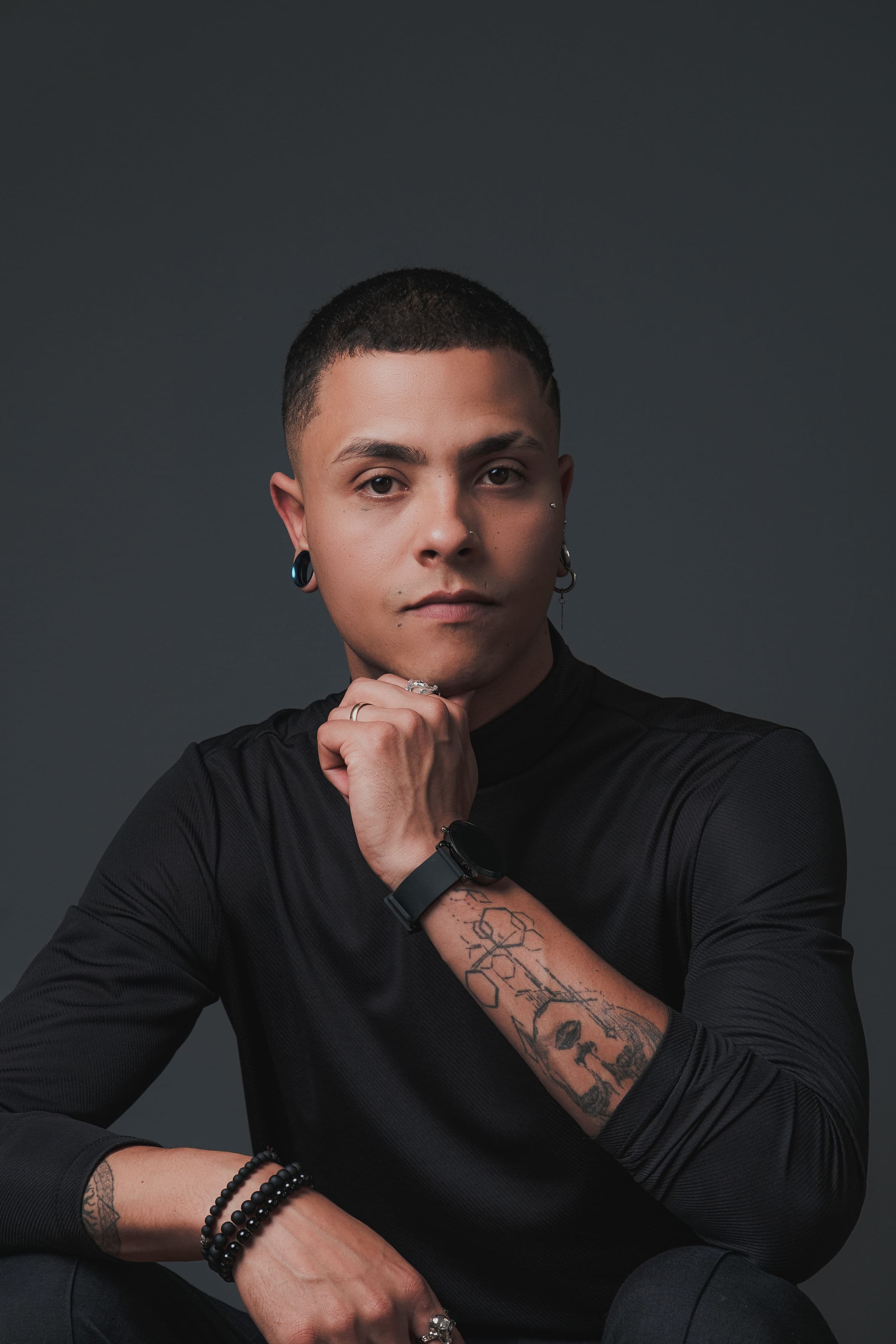 Iury Santos em retrato vertical, com a mão apoiada sob o rosto