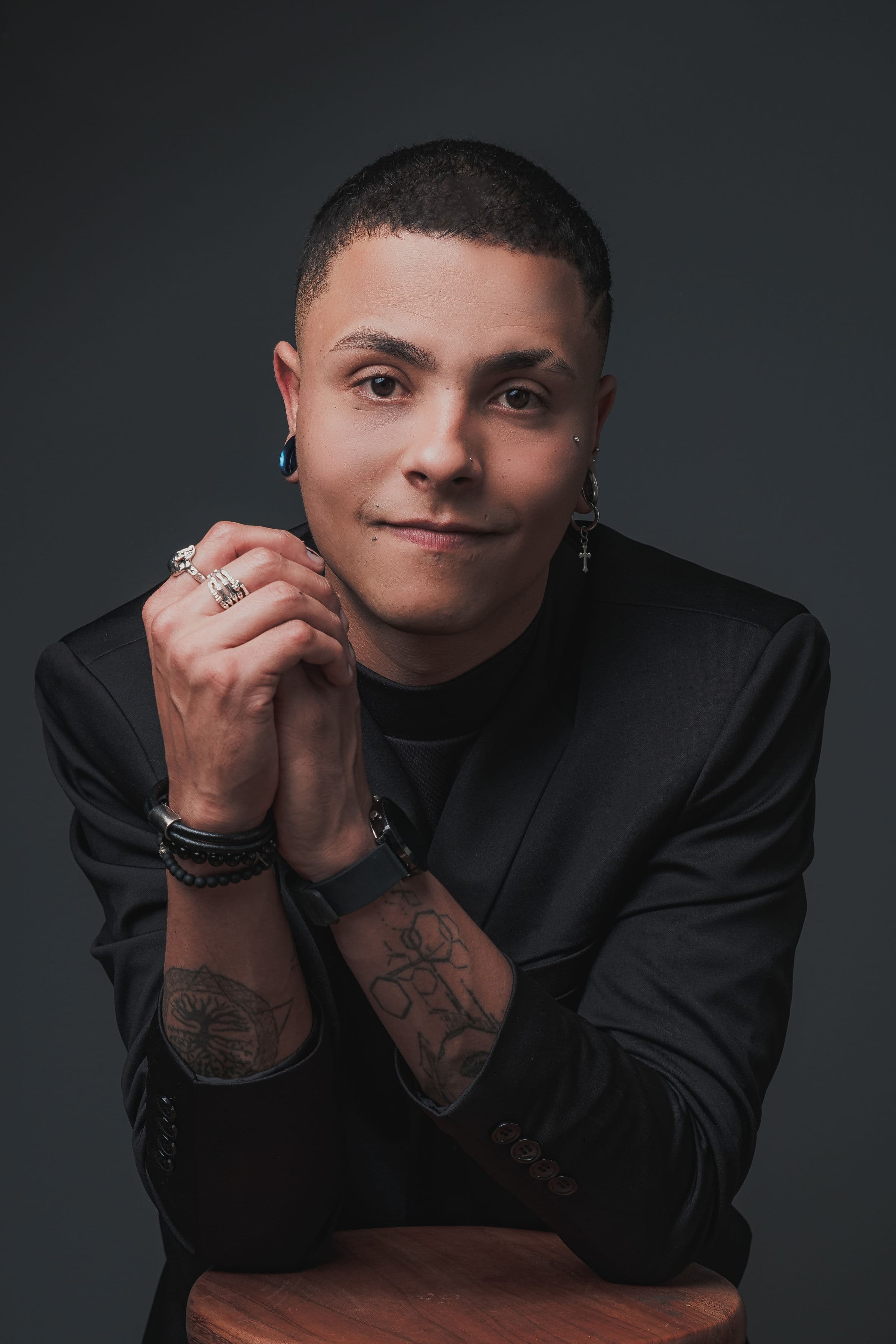 Iury Santos em retrato frontal, com roupa preta e fundo escuro